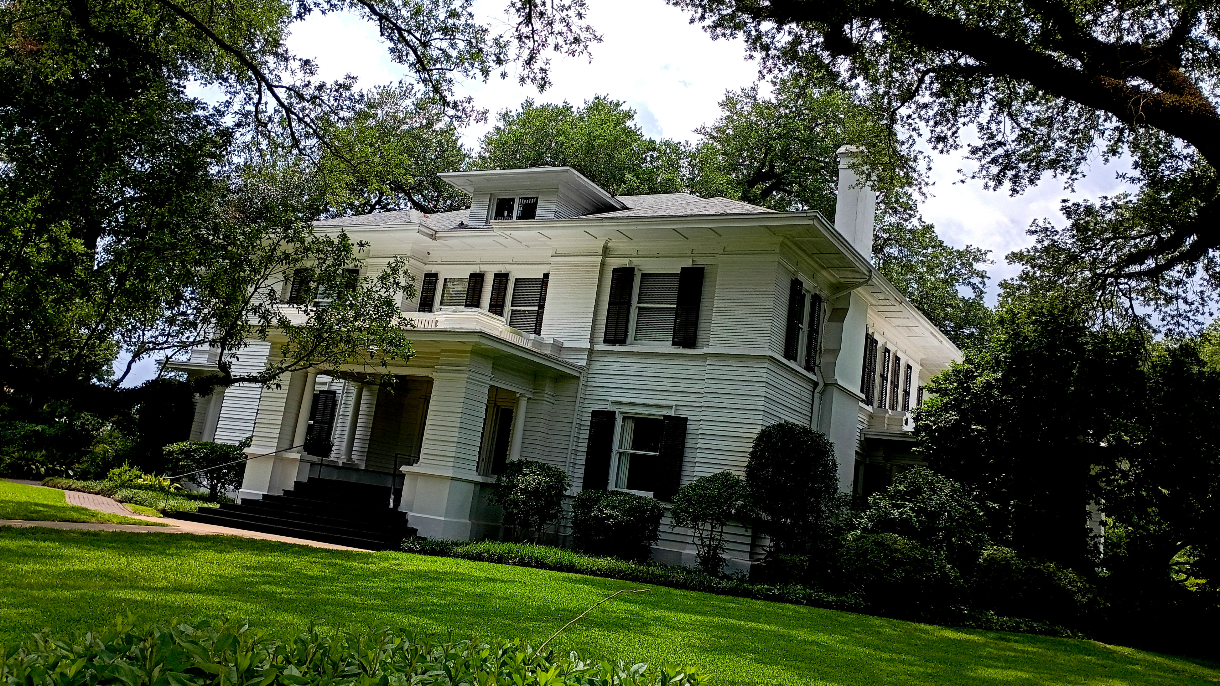 The white exterior and front porch of Rogers-Green House in Laurel, Mississippi